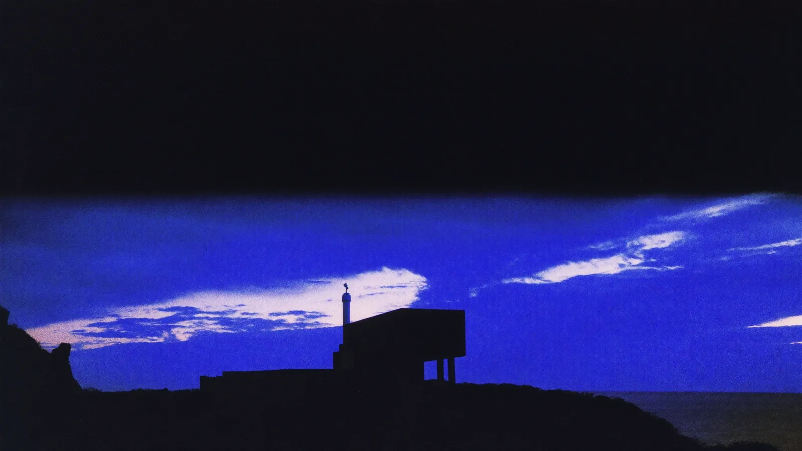 A concrete headland beneath a dramatic indigo dusk sky — sky replacement.