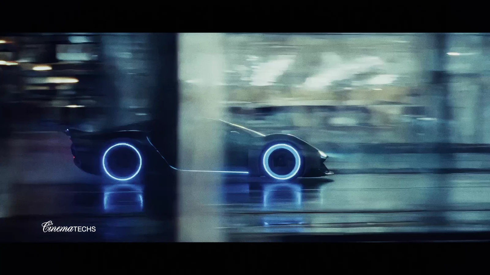 Chrome concept car, close surfacing detail catching the blue rim light on wet metal.