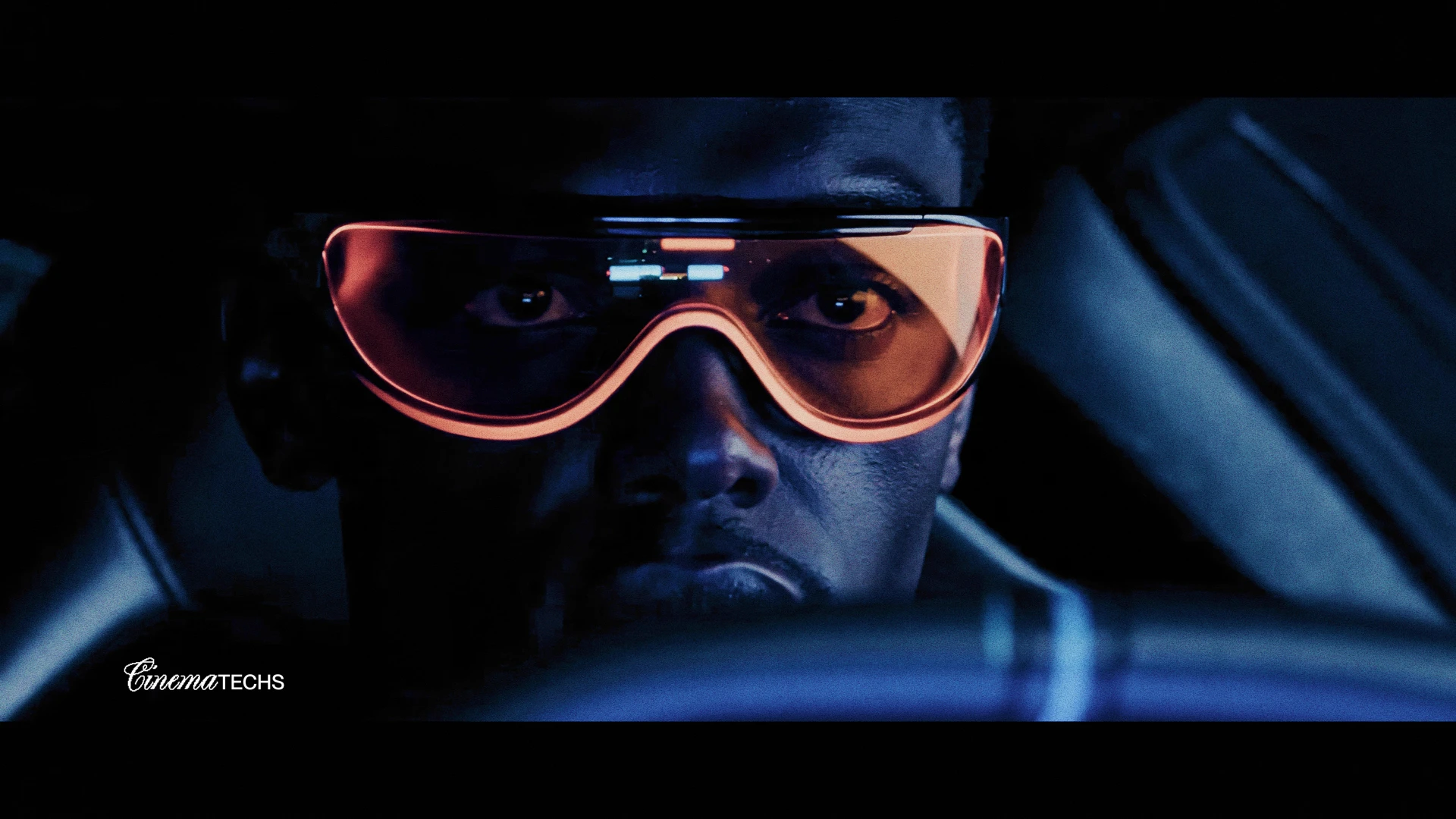 Chrome concept — the driver in amber goggles, the car's blue world reflected in the lens.
